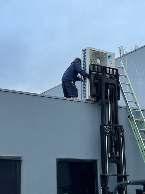 Lifting a Daikin condenser onto a commercial roof